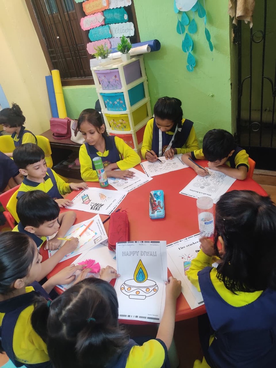 Children colouring Diwali worksheets at a round table