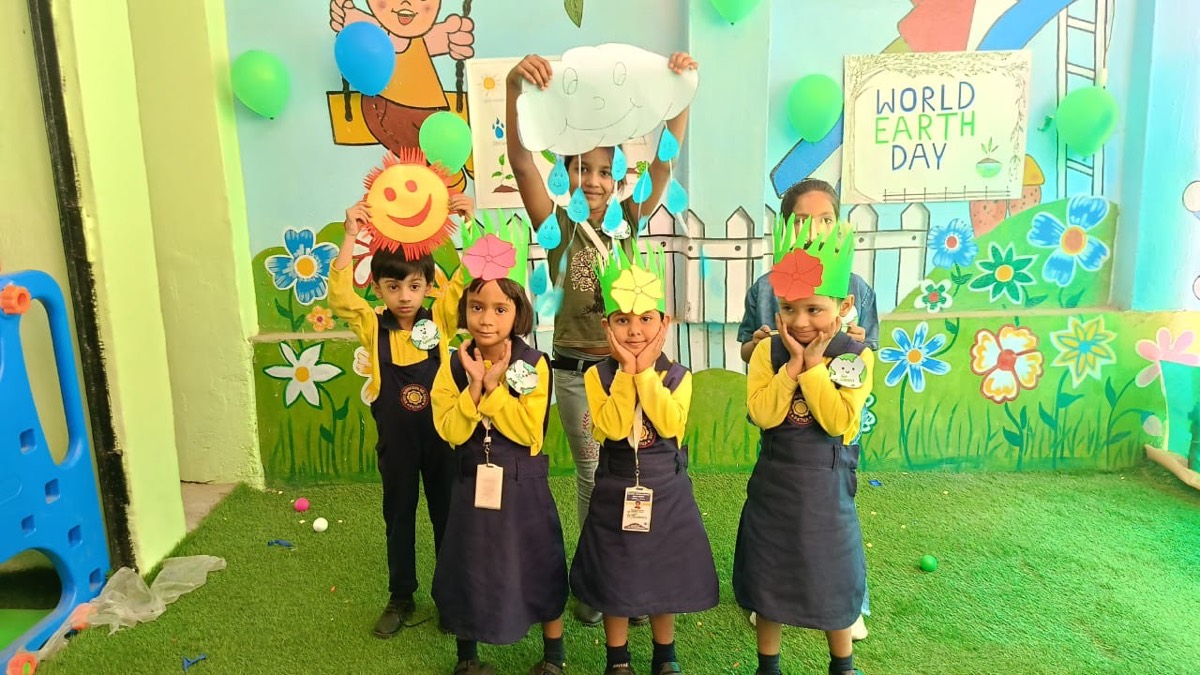Children wearing flower headbands beneath a World Earth Day display board