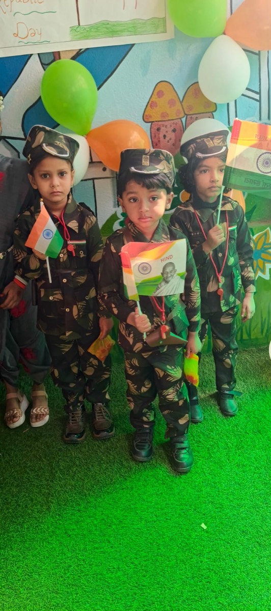 Three children dressed in army uniforms holding Indian flags at a fancy dress event