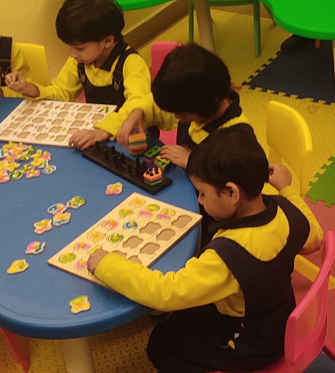 Children working on wooden shape puzzles