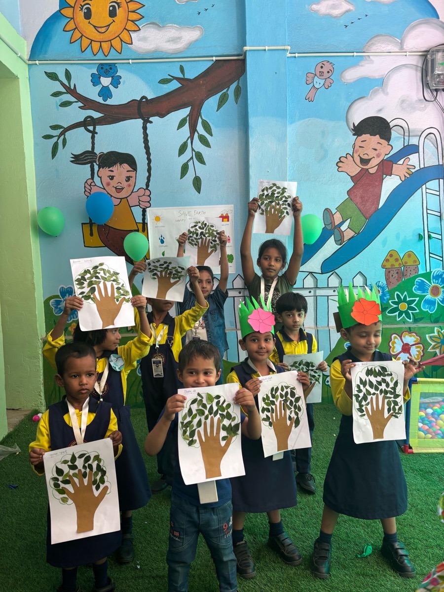 Children holding up handprint tree paintings they made