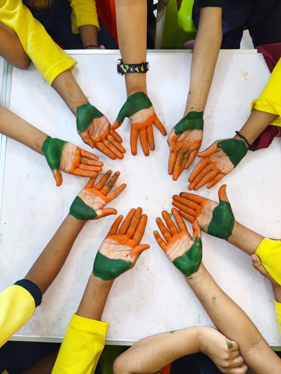 Children's palms painted in the Indian tricolour, arranged in a circle